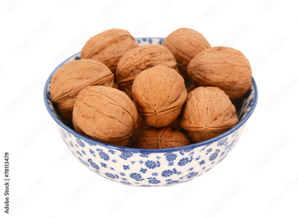 Walnuts in shells, in a blue and white china bowl Walnuts in shells, in a blue and white china bowl