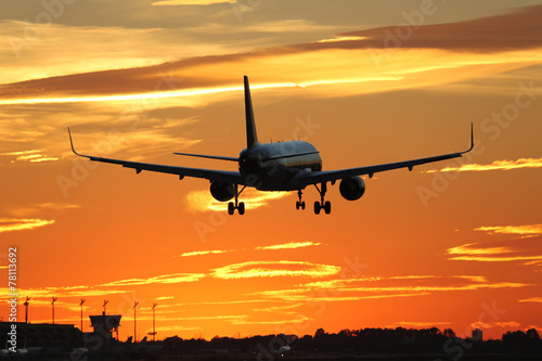 Flugzeug beim Landen auf Flughafen im Sonnenuntergang w  hrend R