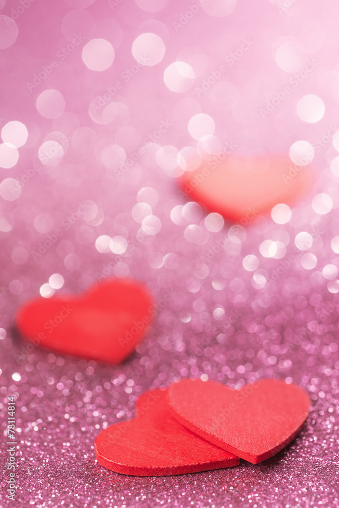 Fototapeta premium Red hearts over abstract glitter background
