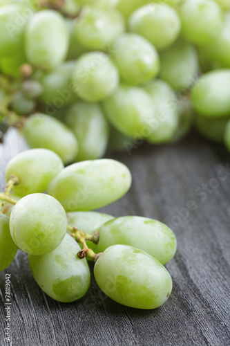ripe green grapes on black wood table