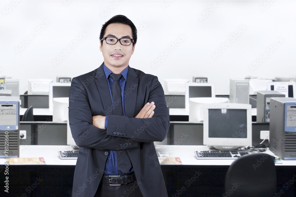 Successful young employee standing in office
