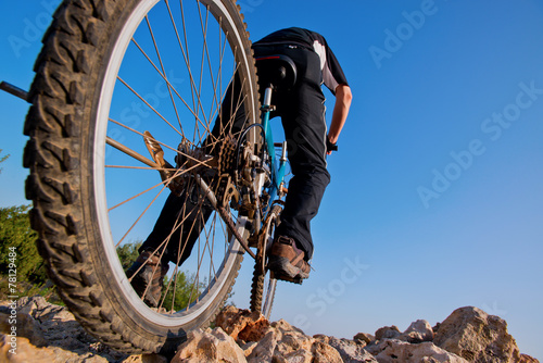 cyclist riding mountain bike on rocky trail