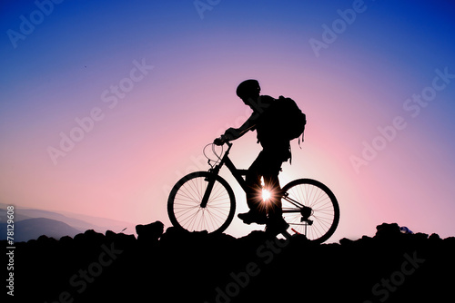 Silhouette of a man on mountain bike at sunset