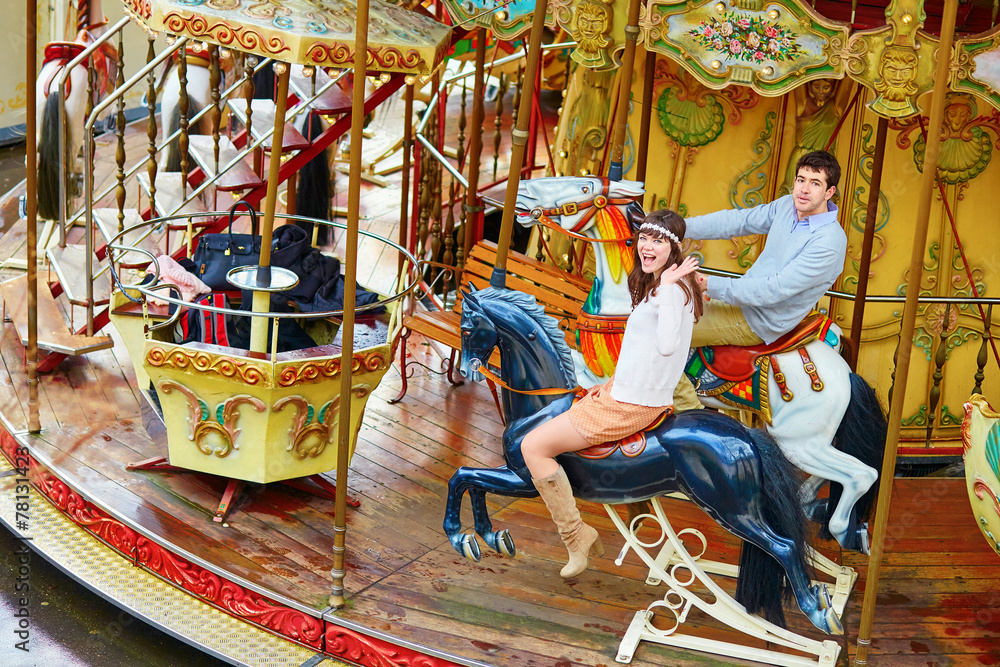 Happy couple on the merry-go-round in Paris