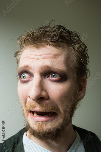 frightened man with red painted eyes. photo