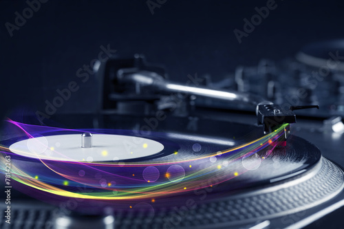 Turntable playing vinyl with glowing abstract lines