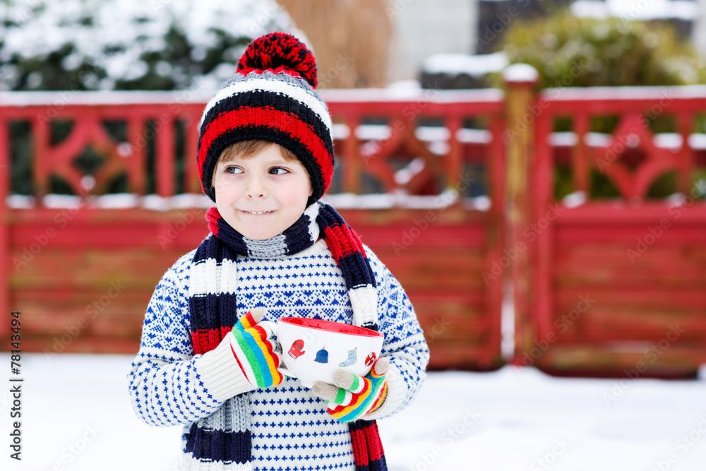 Funny little child holding big cup with snowflakes and hot choco Funny little child holding big cup with snowflakes and hot choco