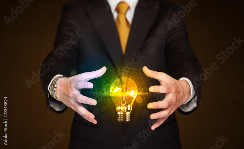 Businessman holding light bulb
