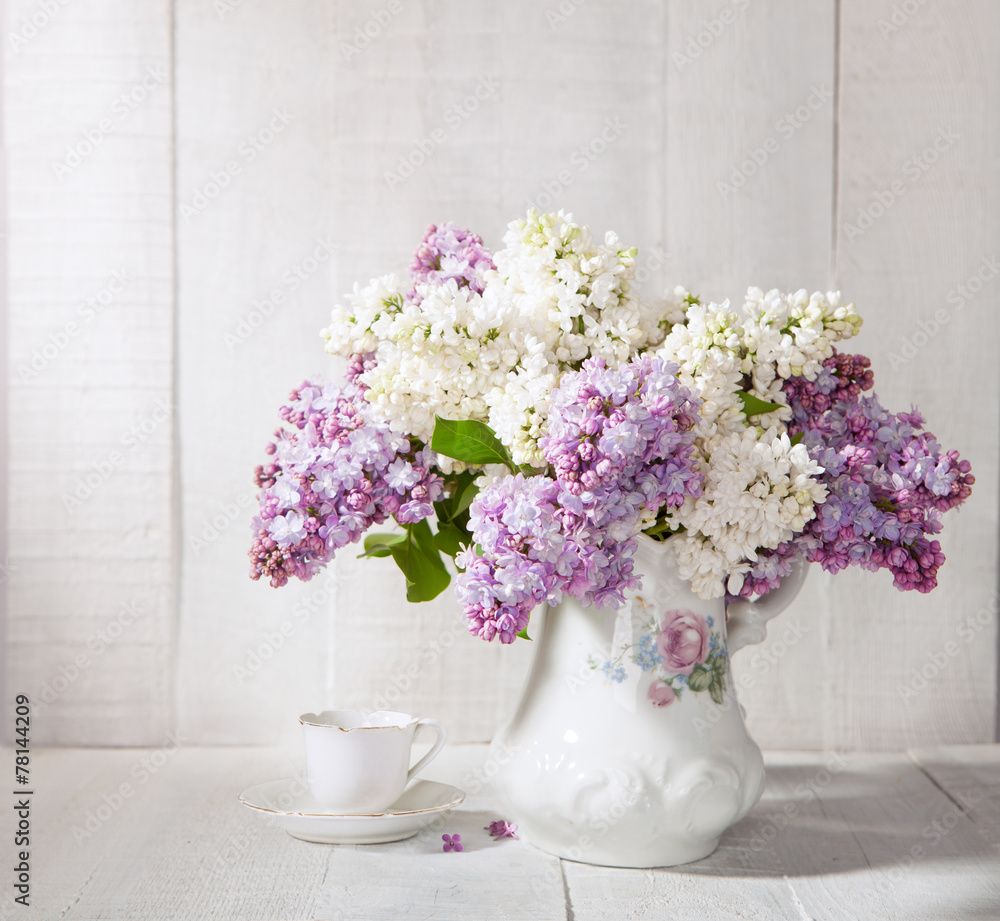 Lilac Bouquet and cup of coffee against wooden table. Lilac Bouquet and cup of coffee against wooden table.