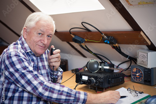 Enthusiastic middle-aged radio-amateur at his station