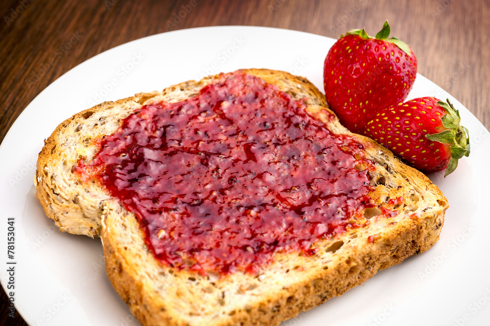 Macro closeup of delicious strawberry jam on whole wheat toast Macro closeup of delicious strawberry jam on whole wheat toast