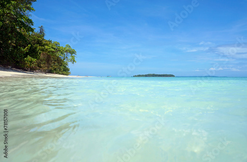 Water surface and tropical beach with an island