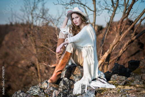 Fashion woman in country style sitting on the canyon rock photo