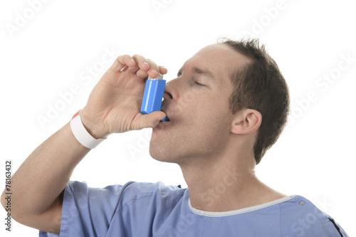 Young man using an asthma inhaler as prevention