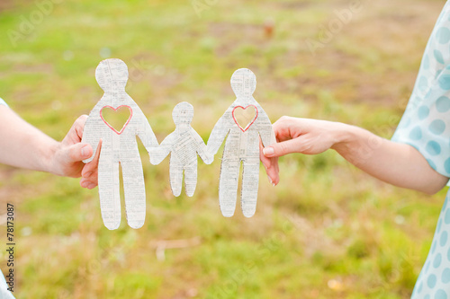 Couple holding paper picture of family