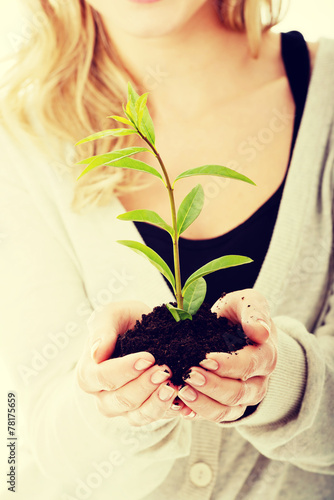 Woman with plant and dirt in hand