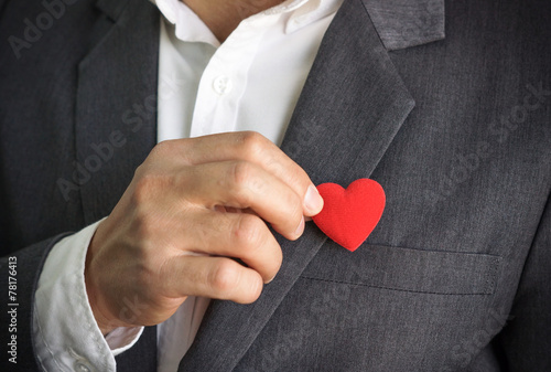 Fotografía Businessman pulling out a red heart from the pocket of his suit