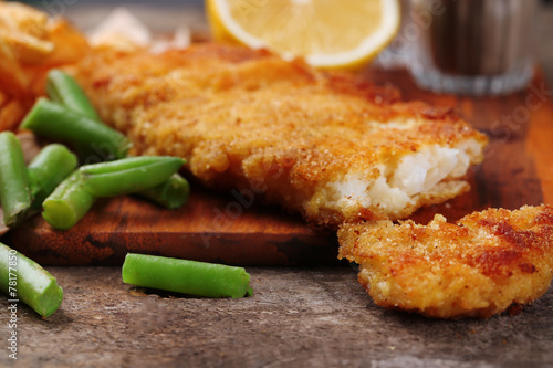 Breaded fried fish fillet and potatoes with asparagus and lemon