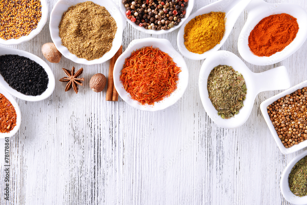 Different kinds of spices in ceramics bowls and spoons Different kinds of spices in ceramics bowls and spoons