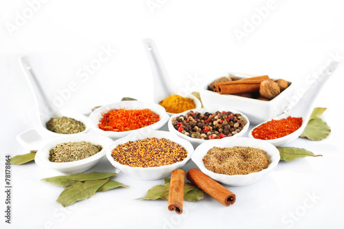 Fototapeta Naklejka Na Ścianę i Meble -  Different kinds of spices in ceramics bowls and spoons isolated