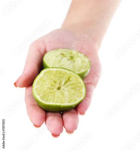 Female hand holding two pieces of lime isolated on white