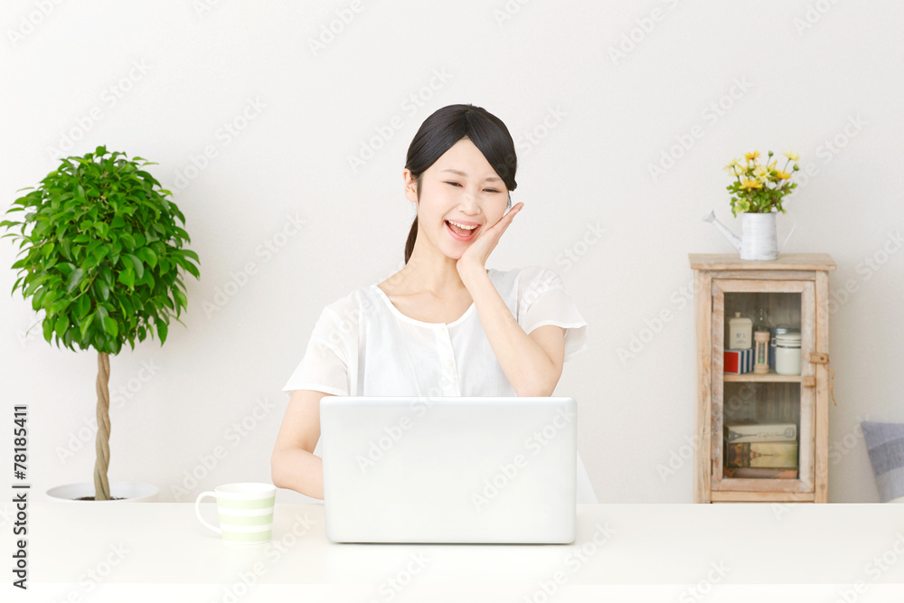 パソコンの前で驚く女性