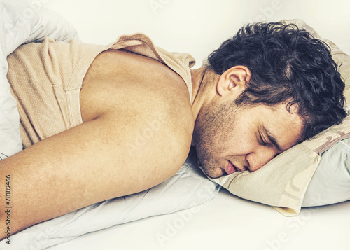 Young man sleeping in bed photo