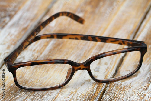 Reading glasses on rustic surface, closeup