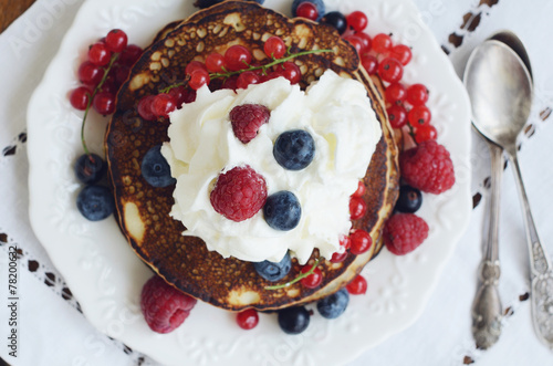 Homemade thin pancakes with whipped cream and fresh berries