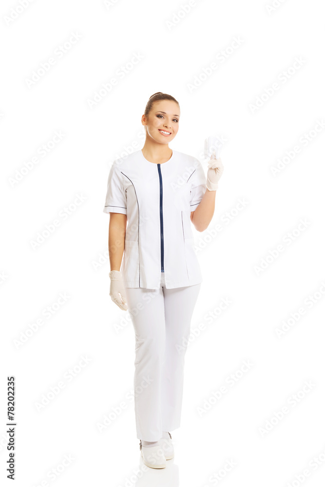 Full length female dentist holding a tooth model Full length female dentist holding a tooth model