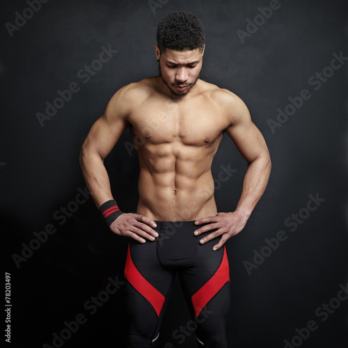 Athletic man on black wall background