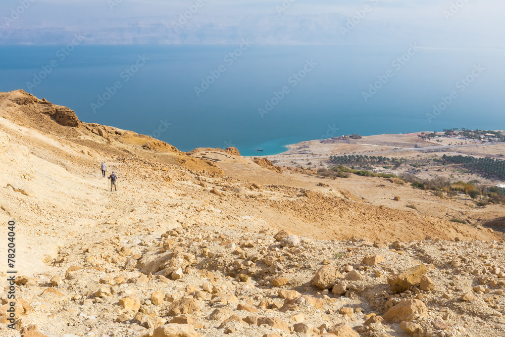 Couple walking desert trail down to Dead sea. Couple walking desert trail down to Dead sea.