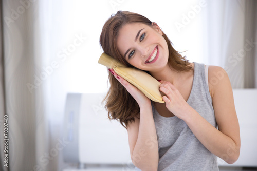 Canvas Print Portrait of a smiling young woman with a hot water bottle