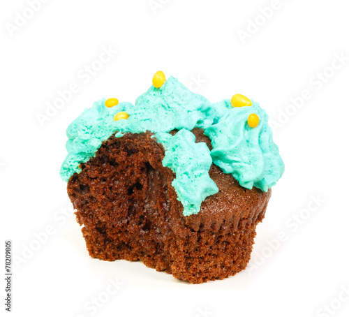 Cupcake with blue frosting of which one bite taken