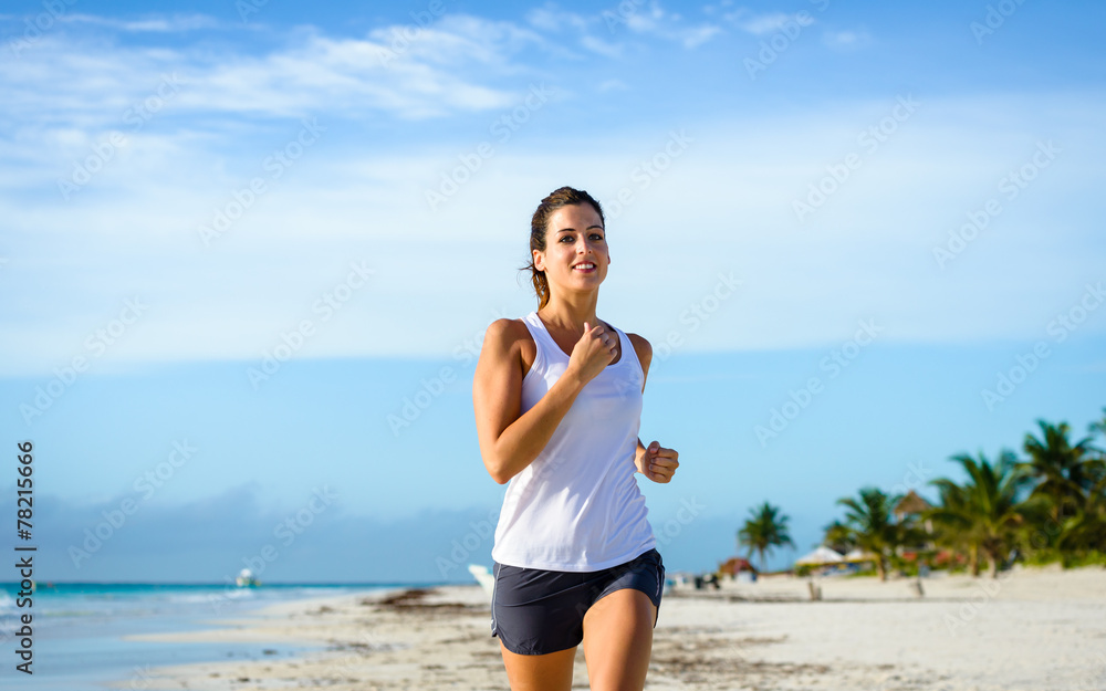 Cheerful woman running at tropical beach