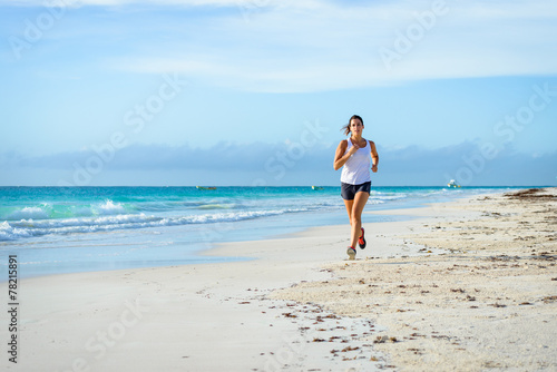 Woman running at tropical beach © Dirima