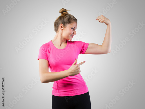 Fényképezés Muscular woman pointing on her bicep