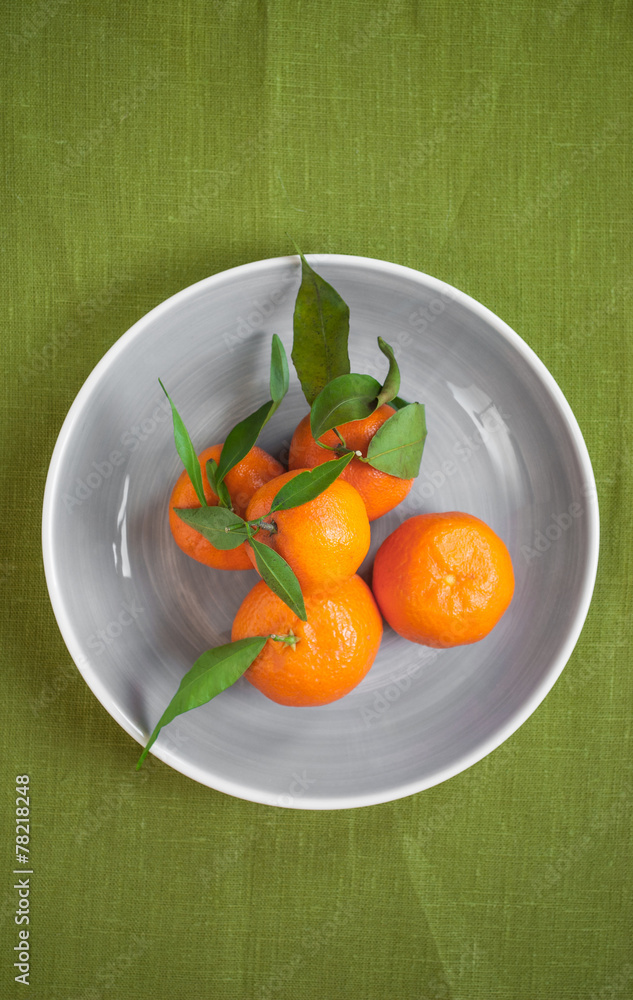 Tangerines on green fabric background
