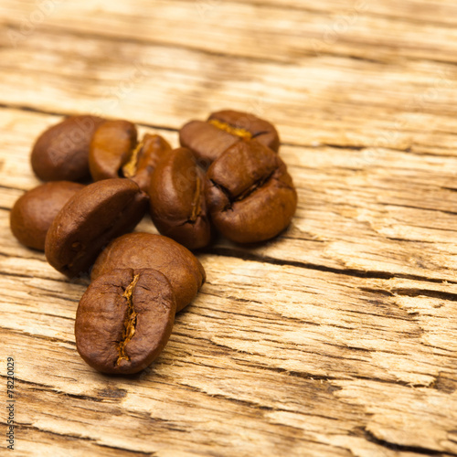 Roasted coffee beans on old wooden table - close up studio shot