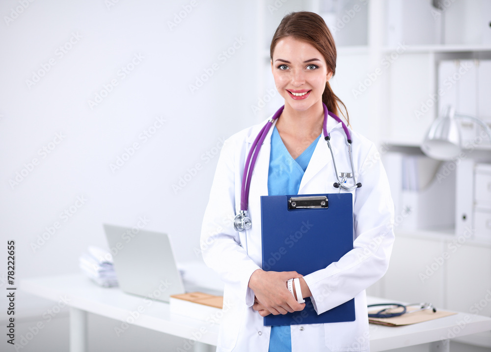 Smiling female doctor with a folder in uniform standing at Smiling female doctor with a folder in uniform standing at