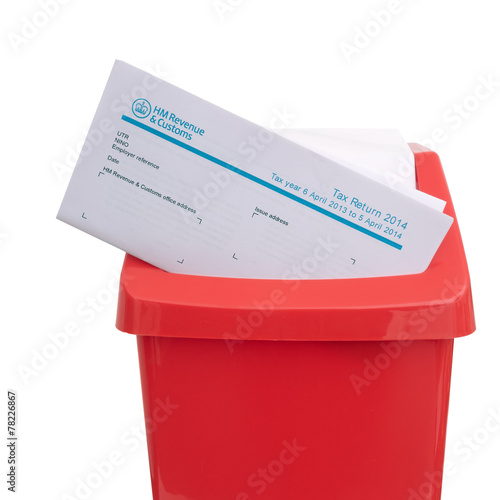 UK tax return in red plastic rubbish bin. Tax avoidance, evasion photo