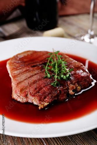 Grilled steak in wine sauce with bottle of wine