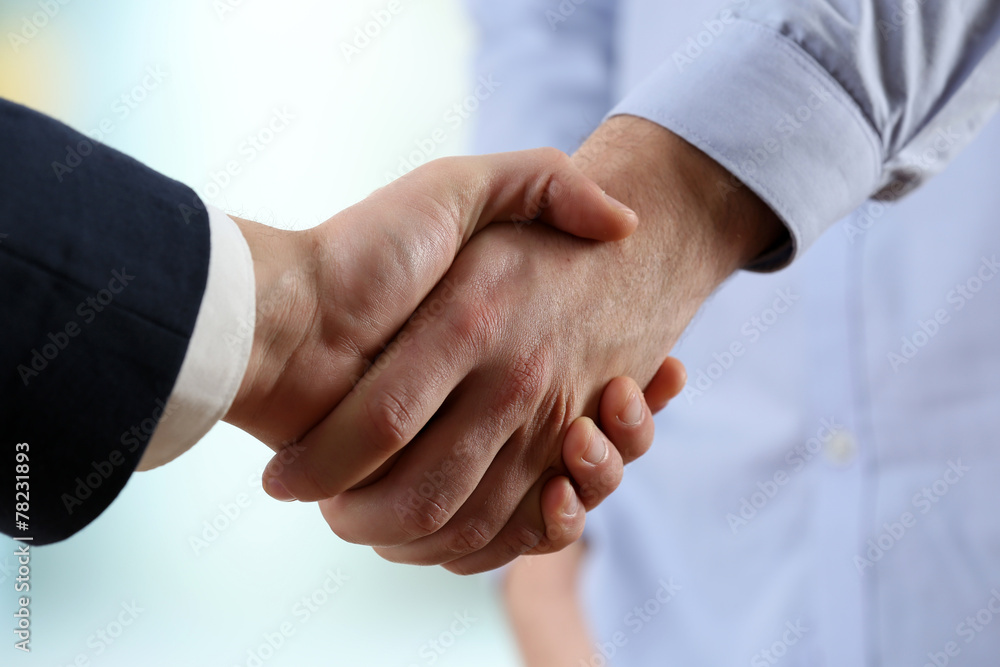 Business handshake on bright background Business handshake on bright background