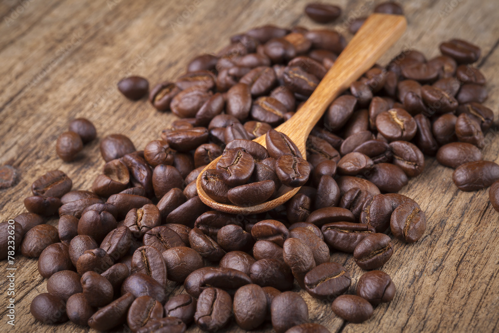 Fototapeta premium roasted coffee beans in wooden spoon placed on coffee beans as b