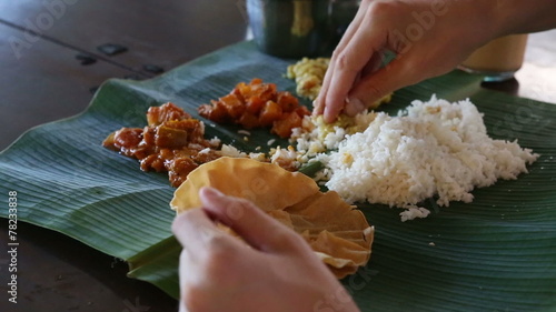 white man eats with his hands indian food from banana leaf like 