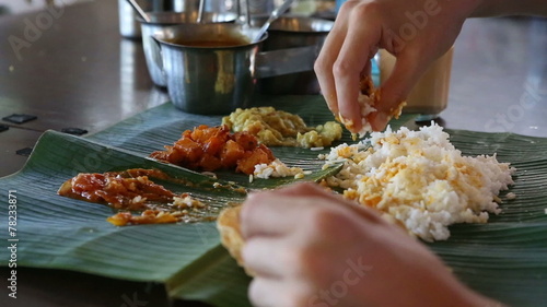 white man eats with his hands indian food from banana leaf like 