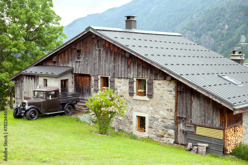 Fototapeta premium Old house and vintage car in the european Alps