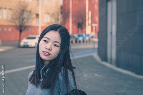 Young beautiful Chinese girl posing in the city streets © tinx