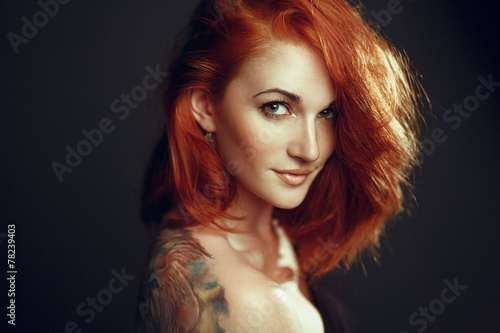 girl with red hair and with tattoo on shoulder