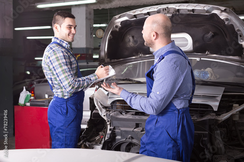 Examining car for damage in workshop